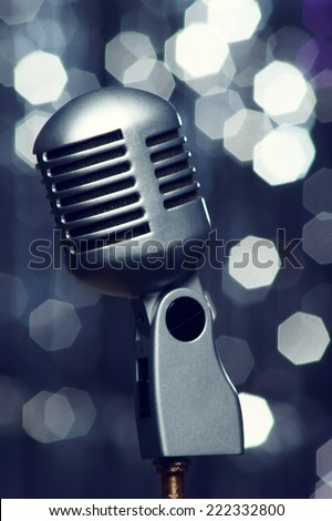 close up of retro metal microphone or mic against festive bokeh background        