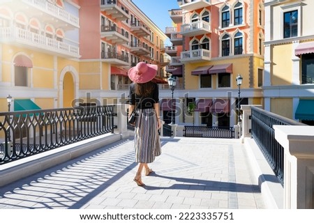 A tourist woman enjoys the sightseeing view to the Venice like Qanat Quartier on the Pearl in Doha, Qatar Royalty-Free Stock Photo #2223335751