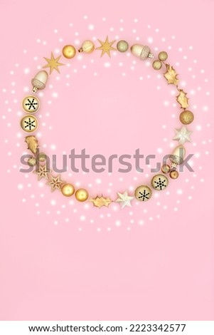 Fantasy Christmas wreath with snow and tree bauble ornaments on pastel pink background. Magical festive composition for winter Xmas and New Year.