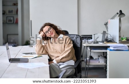 Young adult happy smiling professional business woman, relaxed female company office worker, satisfied pretty businesswoman corporate employee sitting in chair at modern work desk, looking at camera. Royalty-Free Stock Photo #2223351393
