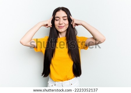 Young caucasian woman isolated on white background focused on a task, keeping forefingers pointing head.