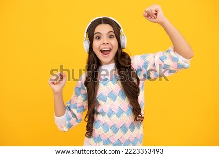 Excited face. Funny kid girl 12, 13, 14 years old listen music with headphones. Teenage girl with headphones listening songs on headset earphone. Amazed expression, cheerful and glad. Royalty-Free Stock Photo #2223353493