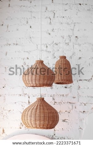 three rattan chandeliers different forms on white brick wall background. Straw lampshade in cozy living room. Eco-friendly interior design using natural materials. Scandinavian interior. copy space. Royalty-Free Stock Photo #2223371671
