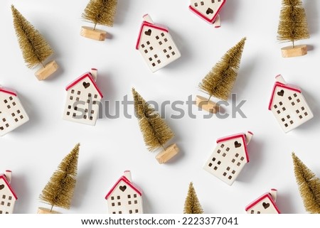 Miniature houses and golden fir trees on white background. Winter cute decorations. Cozy small world. Christmas decorations, holiday concept. 