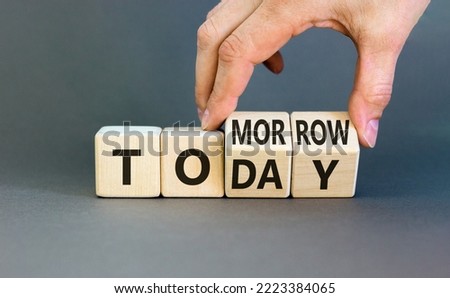 Do it today not tomorrow. Businessman turns wooden cubes and changes the word 'tomorrow' to 'today'. Beautiful grey background, copy space. Business and tomorrow or today concept.