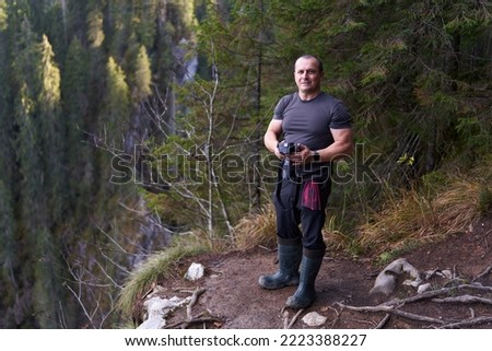 Nature photographer in his element, in the middle of the mountains with his camera
