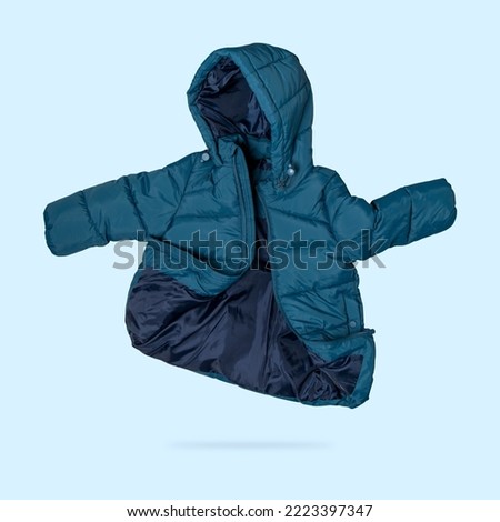 Green emerald flying children's winter autumn jacket with hood isolated on blue background. Waterproof jacket for child, warm down jacket. Cutout clothing mockup. Fashion, style, outerwear