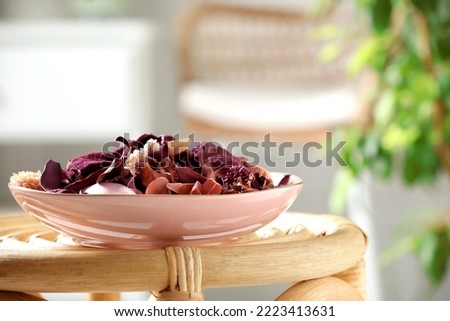 Aromatic potpourri of dried flowers in bowl on wicker table indoors Royalty-Free Stock Photo #2223413631