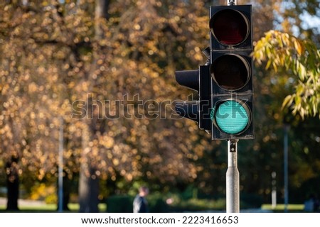 Green traffic light in semaphore close-up. Bright colored autumn background. Royalty-Free Stock Photo #2223416653