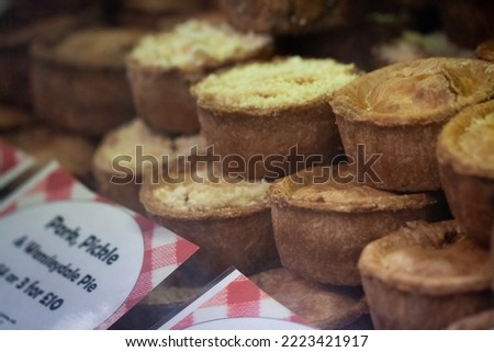 Melton Mowbray Pork Pies for sale pictured behind a glass counter of a local pie shop