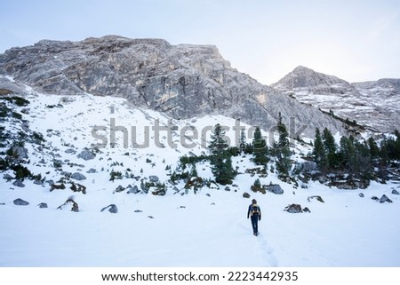 hiker in mountains enjoying outdoor hiking activity walking through snow under magnificent mountains