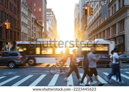 People, cars, bikes and buses traveling through a busy intersection on 5th Avenue and 23rd Street in New York City with sunlight shining in the background Royalty-Free Stock Photo #2223445623