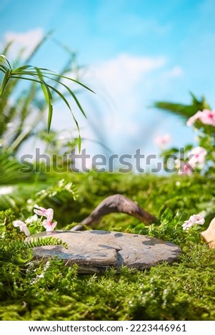 Front view of the stone podium showcases products in a garden with flowers, plants, and branches. Empty platform. Royalty-Free Stock Photo #2223446961