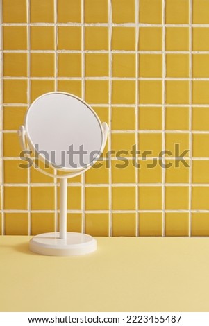 white Mirror on mosaic tiles wall inside the bathroom. Background for display cosmetic products. yellow bathroom background
