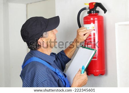 A Professional checking aFire extinguisher Royalty-Free Stock Photo #222345601