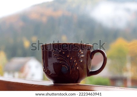 Breakfast. A large brown cup with a hot drink outdoors against the background of the mountain close-up. Coffee, tea