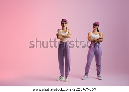 Cheerful young woman standing next to her metaverse avatar in a studio. Happy young woman smiling at the 3D simulation of herself. Young woman exploring virtual reality. Royalty-Free Stock Photo #2223479859