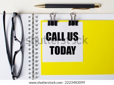 Paper with the text CALL US TODAY a yellow background, glasses, pen, top view, school, education, knowledge, business.