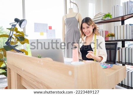 Asian female clothing designers in Thailand are communicating with customers through laptops in their home office. to cut the dress according to the customer's request