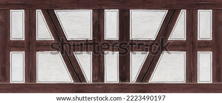 Half-timbered detail - brown wooden beams and white plastered spaces with painted gray decorative stripes Royalty-Free Stock Photo #2223490197