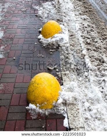 Concrete parking bollards (barriers, blocks) on the road in winter. 