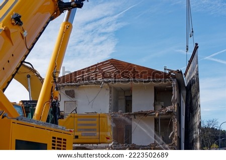 Deconstruction site with tearing down of an apartment building with mobile crane holding dust protection canvas on a sunny autumn day. Photo taken November 7th, 2022, Zurich, Switzerland.