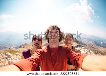 Photo of a group of friends taking a selfie. Smiling and happy people while traveling in the mountains. vacation and rest.