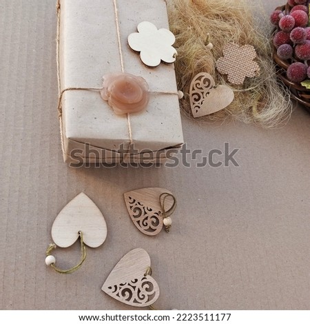 Wooden hearts and flowers, a gift in a vintage wrapper on a solid background. Greeting card in rustic style.