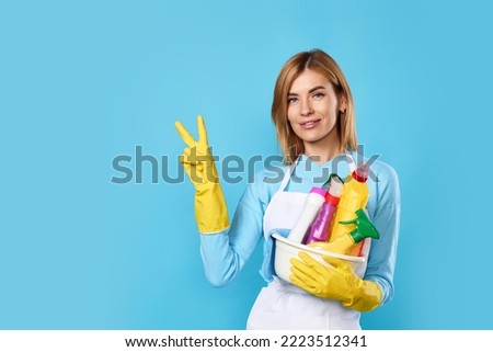 woman in gloves holding bucket of detergents and showing Ok