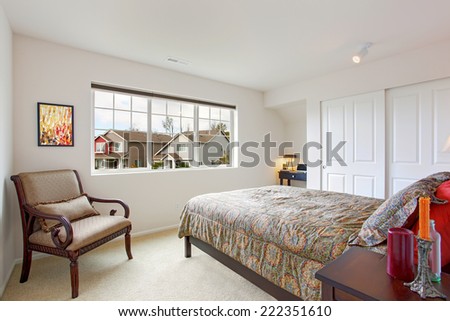 Bright bedroom with closet and office area. Decorated with antique carved wood chair