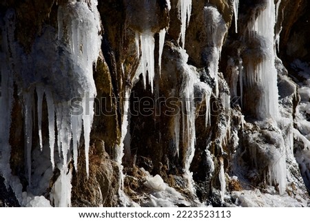 Dramatic, colorful Ice Sickles hanging from cliff