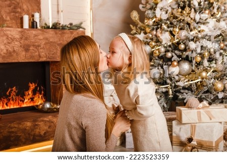 kissing mom and daughter for Christmas. happiness