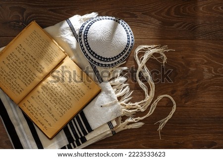 Jewish traditional prayer supplies. Talite, kippah, torah on a wooden table. Shabbatta, Bar Mitzvah, Yom kippur concept Royalty-Free Stock Photo #2223533623