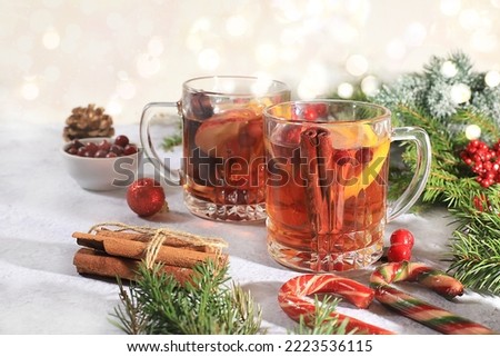 Alcoholic or non-alcoholic cocktail of tangerines, oranges, apples and cinnamon with spices, mulled wine, a warming winter drink in the cold season, Christmas festive grog, winter composition