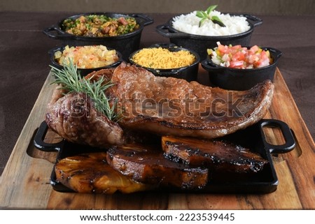 barbecued meat with cassava fried banana rice beans and herb sauce, typical brazilian food Royalty-Free Stock Photo #2223539445