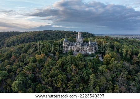 Aerial view on castle marienburg atop a hill with trees Royalty-Free Stock Photo #2223540397