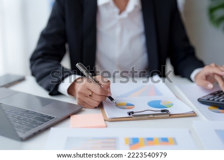 Close-up of a business woman's hands using a calculator to calculate and take notes to audit company accounts, finances, income, balance sheets and budgets.
