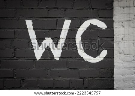 WC toilet inscription on a brick wall. Black and white version