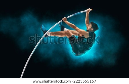 Professional pole vaulter training on black background. Copy space background Royalty-Free Stock Photo #2223555157