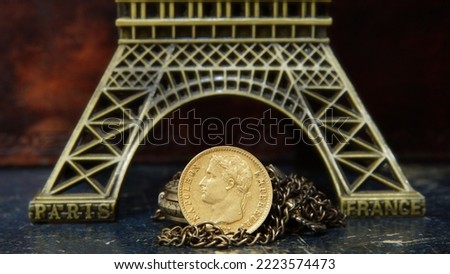 Gold coin 20 francs 1814 France Napoleon against the background of a bronze model of the Eiffel Tower symbols of France
selective focus