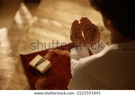 Close up of Muslim believer reciting dua during prayer at home. Royalty-Free Stock Photo #2223591845