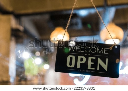 Text plastic sign Come in we're open on window door in café store or restaurant front After coronavirus outbreak Passed, allowing  business to open operate as usual, Sign hanging on glass board