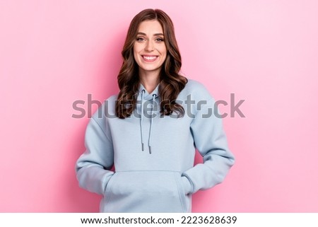 Photo of adorable charming girl dressed grey sweatshirt smiling arms pocket isolated pink color background