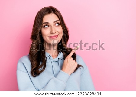 Photo of gorgeous positive lady look indicate finger empty space ad isolated on pink color background
