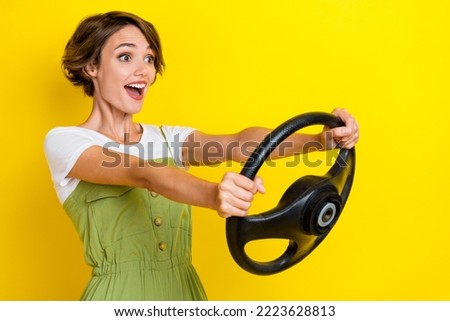 Photo portrait of nice young woman excited driving lesson road traffic dressed stylish khaki clothes isolated on yellow color background