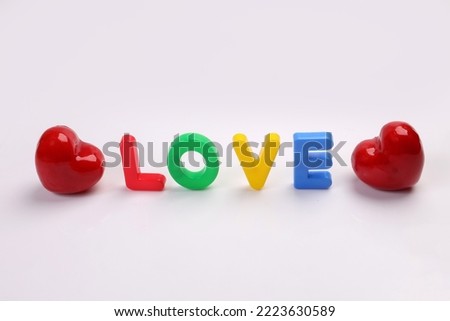 red green blue yellow plastic toy capital font letter alphabet love on white background red hart love shape copy text space concept