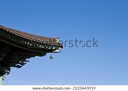 The scenery (bell) seems to be ringing from the end of the eaves in an old traditional Korean temple built a long time ago. Royalty-Free Stock Photo #2223643019