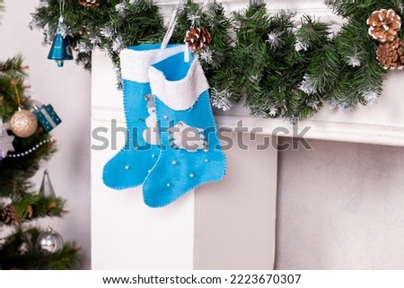 Holiday decorations. blue socks for gifts.Christmas socks hanging on fireplace in room interior.santa stockings