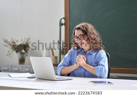 Young happy business woman employee or teacher feeling pleased and excited looking at laptop reading good news online getting salary or career growth, satisfied with great result sitting at work desk. Royalty-Free Stock Photo #2223674583