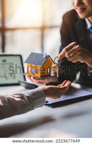real estate agent Delivering sample homes to customers, mortgage loan contracts. Make a contract for hire purchase and sale of a house. and home insurance contracts, home mortgage loan concepts Royalty-Free Stock Photo #2223677649